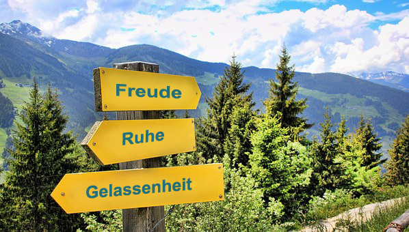 Persönliche Ziele wie Freude, Ruhe, Gelassenheit stehen hier als Beispiel auf Wegweisern, Ihrer Wanderung zu Ihren eigenen Zielen